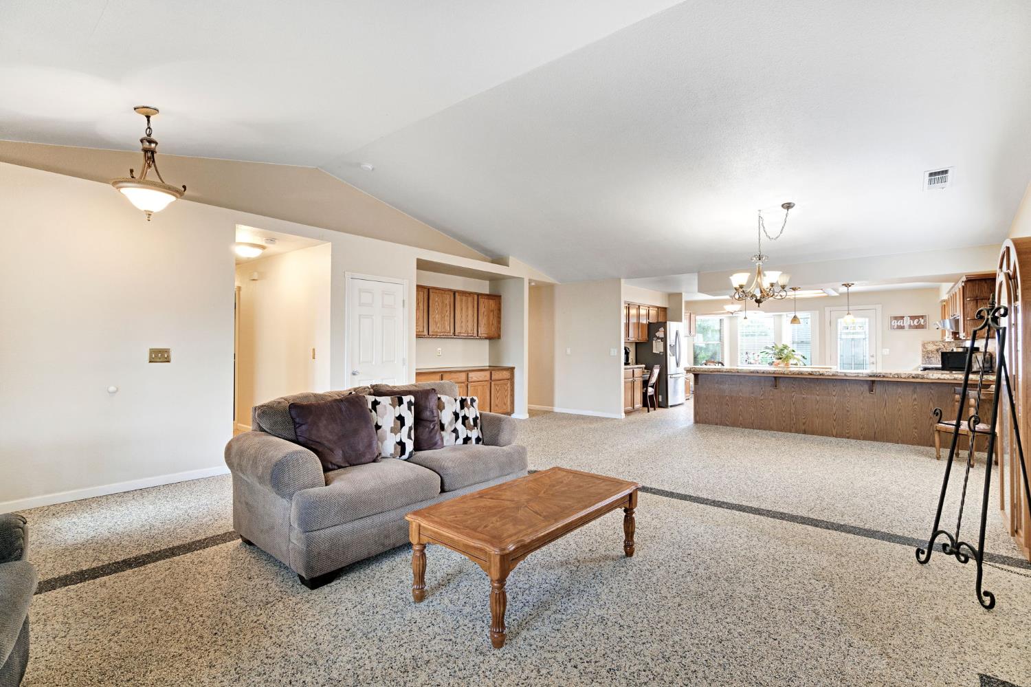 73 Devon Drive Lemoore, CA 93245 - Photo 11 of 32 a living room with furniture and a chandelier