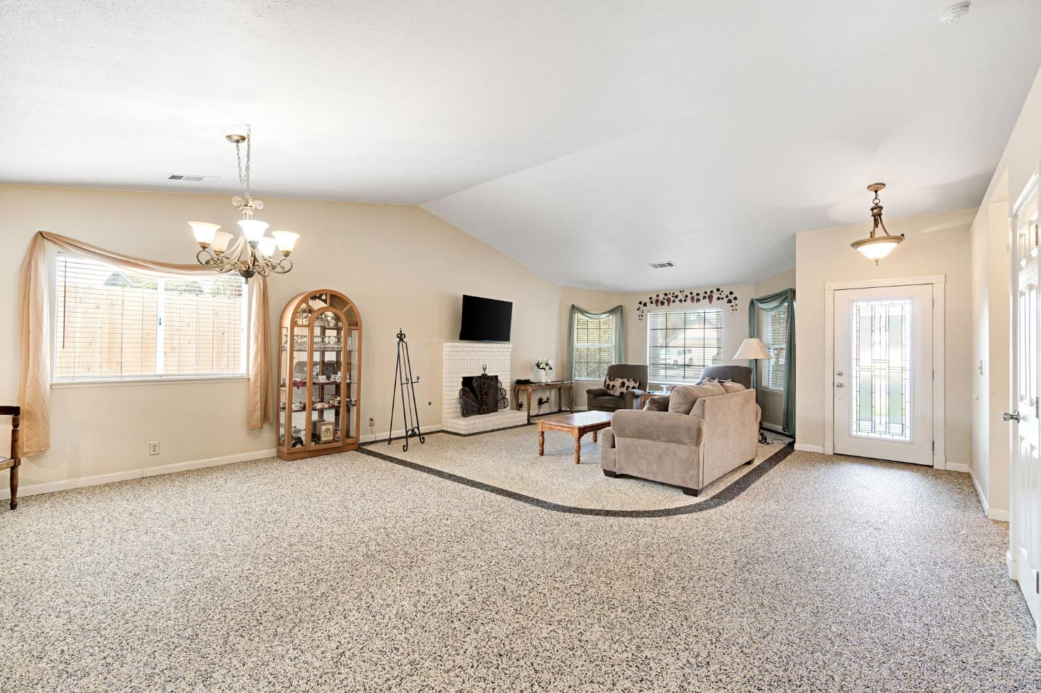 73 Devon Drive Lemoore, CA 93245 - Photo 14 of 32 a living room with furniture a chandelier and a large window
