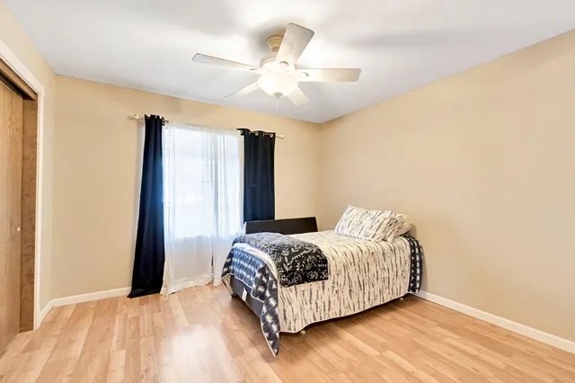 a view of a kitchen with fridge and wooden floor