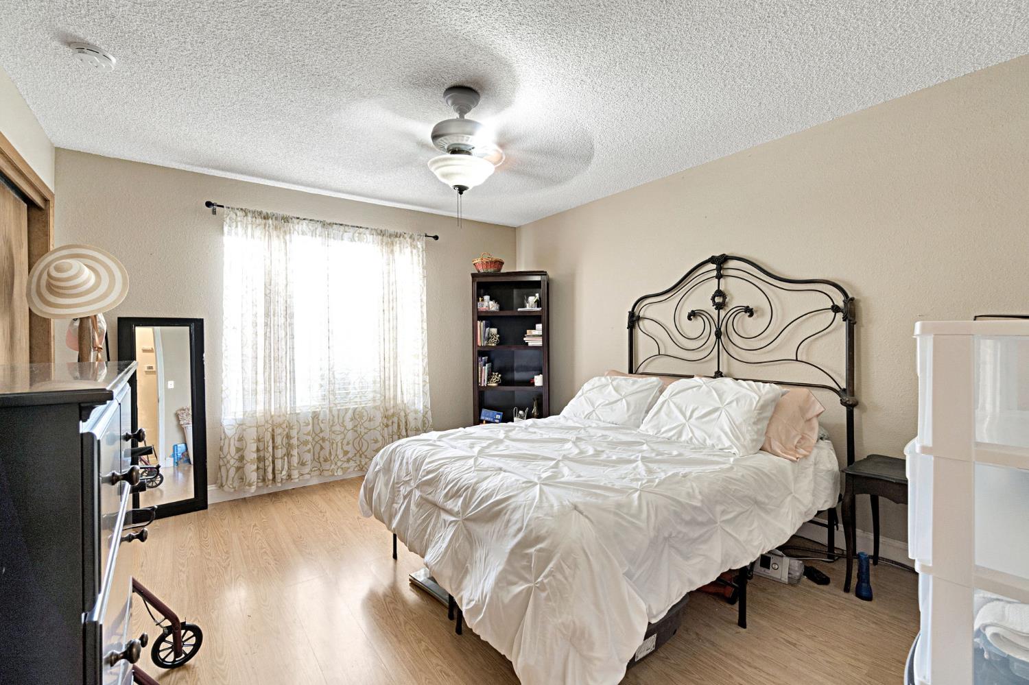 73 Devon Drive Lemoore, CA 93245 - Photo 24 of 32 a bedroom with a bed and a table in it