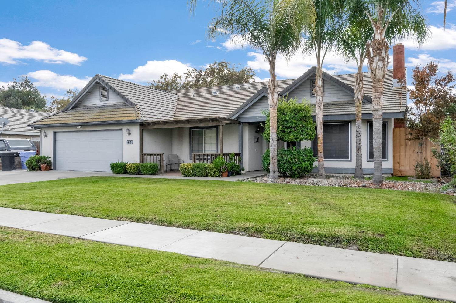 73 Devon Drive Lemoore, CA 93245 - Photo 31 of 32 a front view of a house with a garden and plants