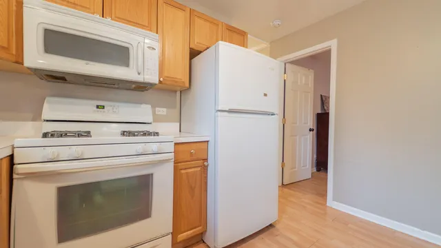 a kitchen with stainless steel appliances a sink a stove and white cabinets