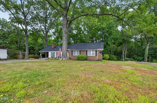 a front view of a house with yard and trees