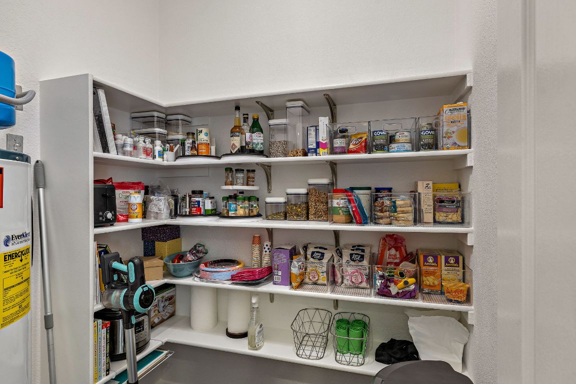 408 Tyree Road Cedar Park, TX 78613 - Photo 11 of 25 a room with a wooden floor shelf and a kitchen view
