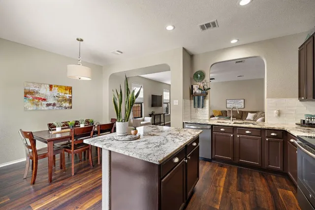 a kitchen with granite countertop cabinets a sink a counter space and stainless steel appliances