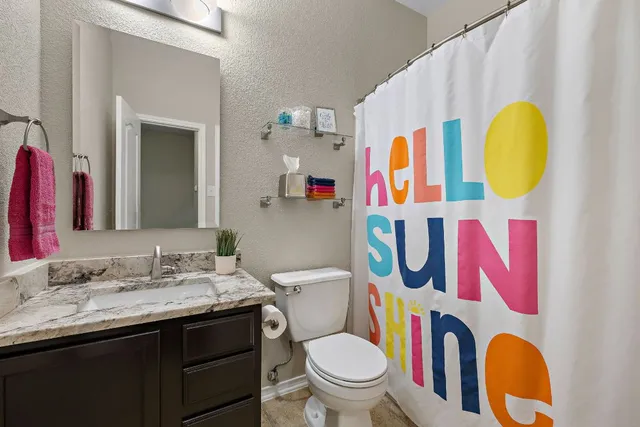 a bathroom with a sink vanity mirror and toilet