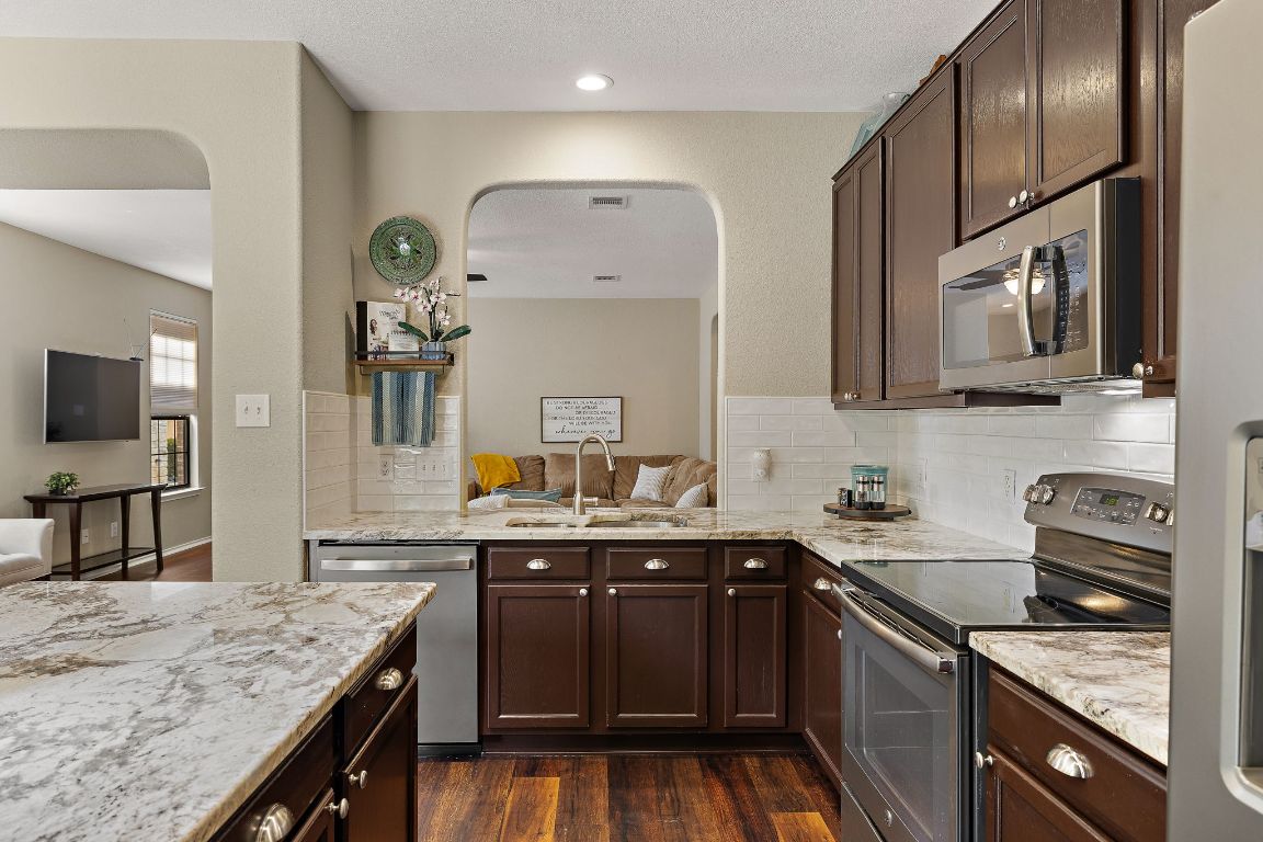 408 Tyree Road Cedar Park, TX 78613 - Photo 8 of 25 a kitchen with stainless steel appliances granite countertop a sink stove and refrigerator