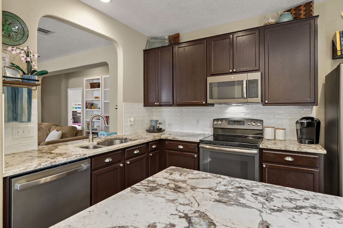 408 Tyree Road Cedar Park, TX 78613 - Photo 9 of 25 a kitchen with a sink stove and microwave
