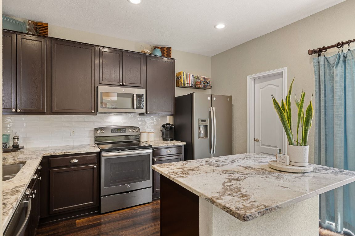 408 Tyree Road Cedar Park, TX 78613 - Photo 10 of 25 a kitchen with refrigerator cabinets and wooden floor