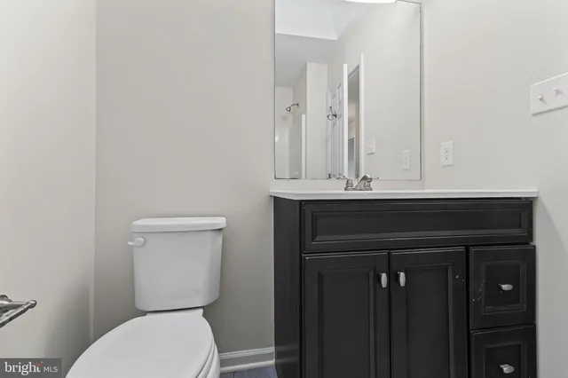 a bathroom with a toilet a sink and mirror
