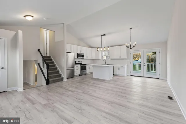 a view of a kitchen with wooden floor and electronic appliances