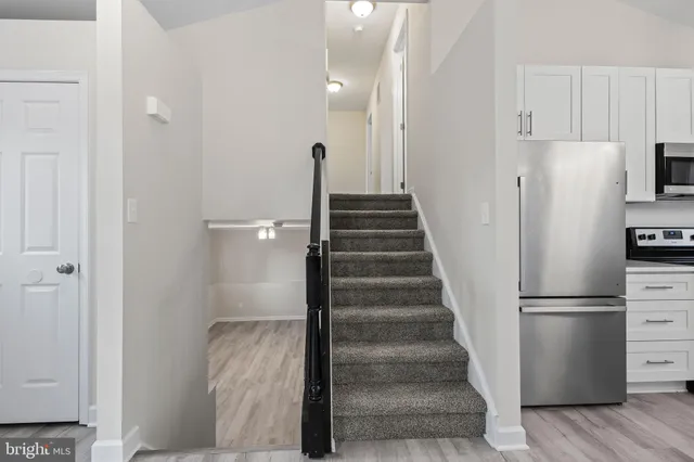 a view of hallway with stairs and wooden floor