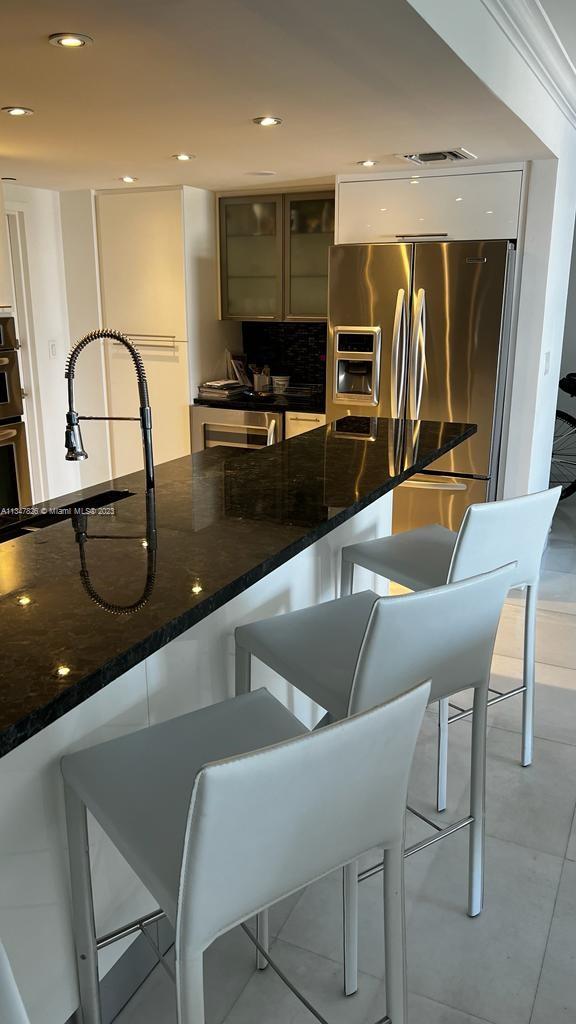 199 Ocean Ln Drive, Unit 1206 Key Biscayne, FL 33149 - Photo 6 of 12 a kitchen with granite countertop a table chairs microwave and sink