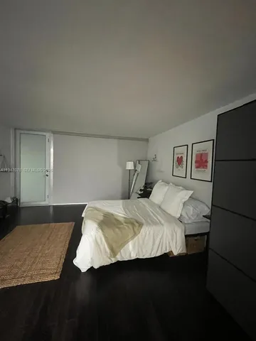 a bedroom with a bed and a refrigerator