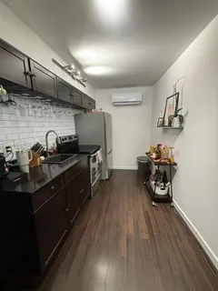 a kitchen with stainless steel appliances a sink stove and wooden floor
