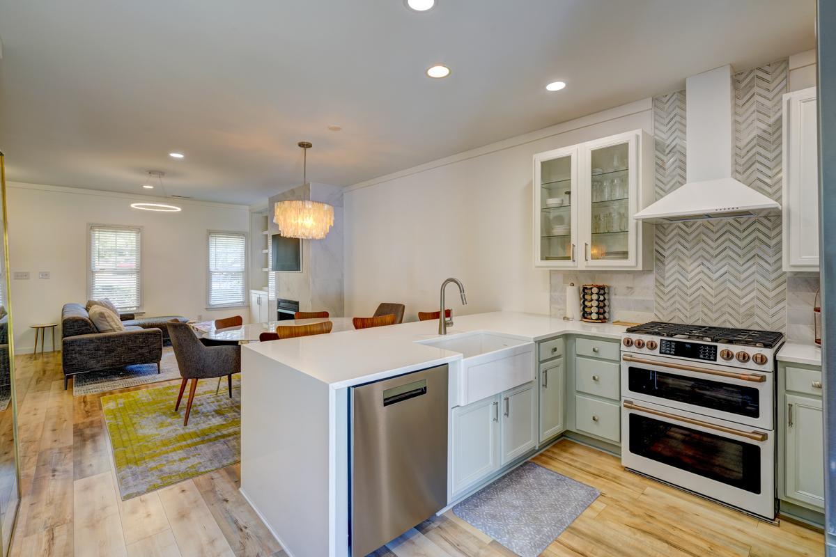 20017 Roark Hoey Loop Chapel Hill, NC 27517 - Photo 13 of 44 a kitchen with a stove a sink a kitchen island a dining table and chairs