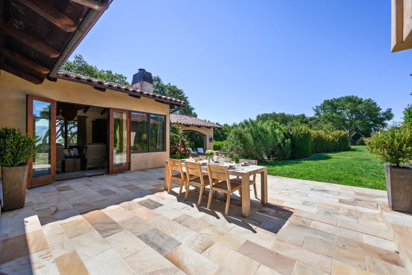 960 Laureles Grade Carmel Valley, CA 93924 - Photo 60 of 76 a view of a patio with a dining table and chairs under an umbrella
