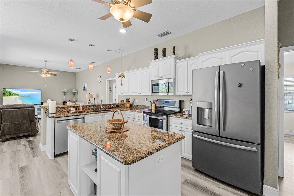 7130 Scarlet Sage Court Punta Gorda, FL 33955 - Photo 13 of 26 a kitchen with stainless steel appliances granite countertop a sink refrigerator and cabinets