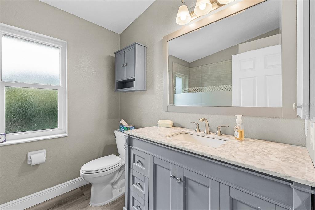 7130 Scarlet Sage Court Punta Gorda, FL 33955 - Photo 18 of 26 a bathroom with a granite countertop toilet sink and mirror