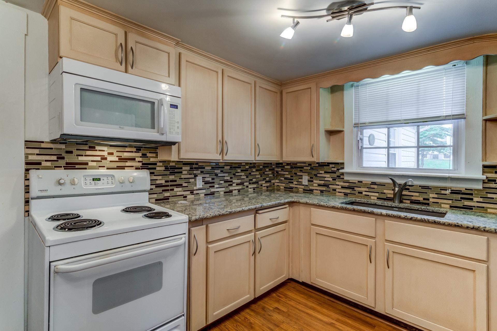 4541 Cowman Road Roanoke, VA 24014 - Photo 9 of 23 a kitchen with granite countertop a stove sink and cabinets