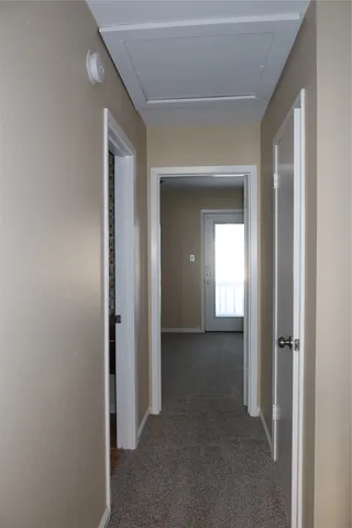 a view of a hallway with wooden shelves