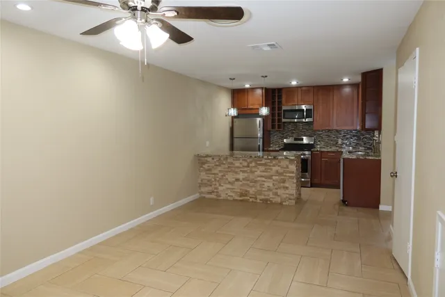 a kitchen with stainless steel appliances kitchen island granite countertop a stove and a sink