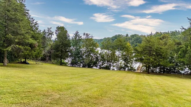 an aerial view of a houses with a yard and lake view