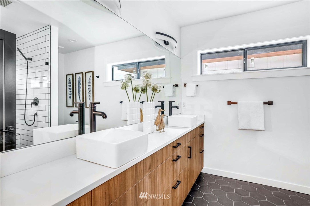 1619 North 50th Street Seattle, WA 98103 - Photo 15 of 37 a bathroom with a double vanity sink a mirror and a bathtub