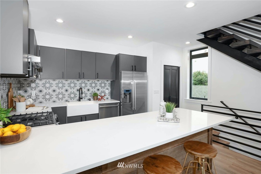 1619 North 50th Street Seattle, WA 98103 - Photo 9 of 37 a kitchen with stainless steel appliances a sink and a refrigerator