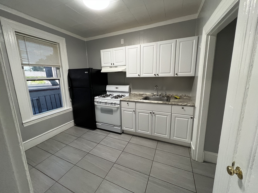 64 Hollis Street, Unit 13 Framingham, MA 01702 - Photo 1 of 7 a kitchen with a refrigerator sink and cabinets