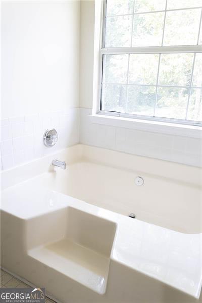 6232 Springwater Lane Lithonia, GA 30058 - Photo 15 of 32 a bathroom with a bathtub and window