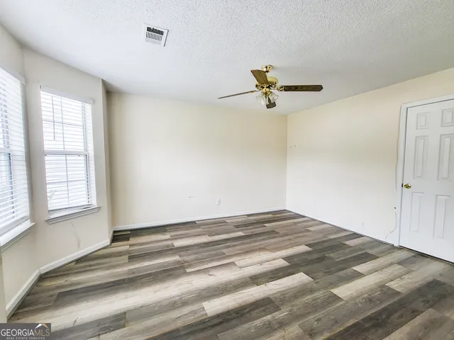 a view of a room with a ceiling fan and a window