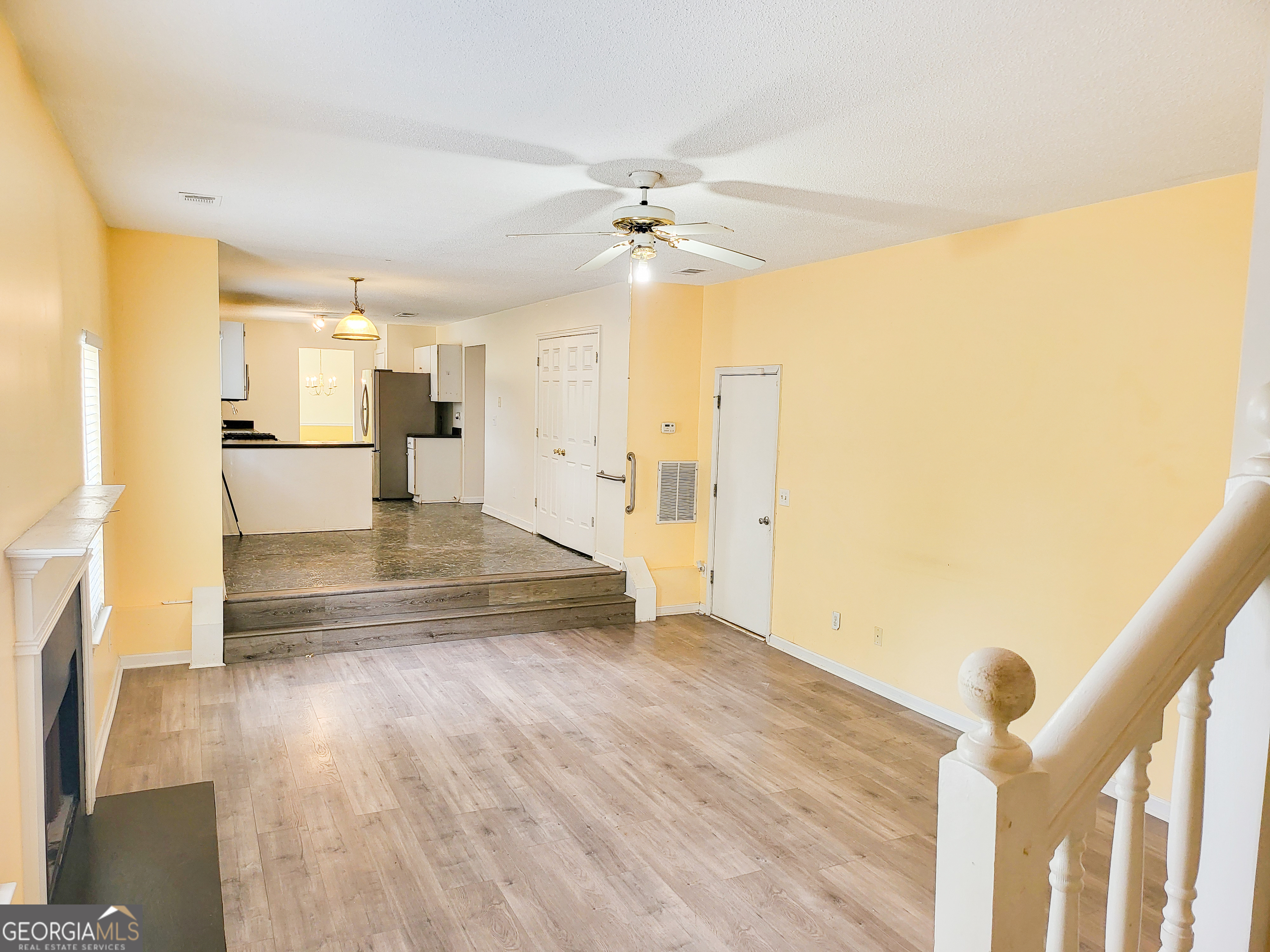 6232 Springwater Lane Lithonia, GA 30058 - Photo 24 of 32 a view of a kitchen with wooden floor and a ceiling fan