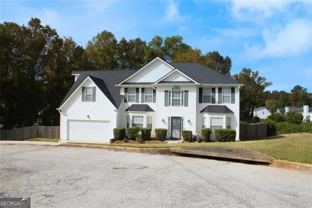 a front view of a house with a yard and trees