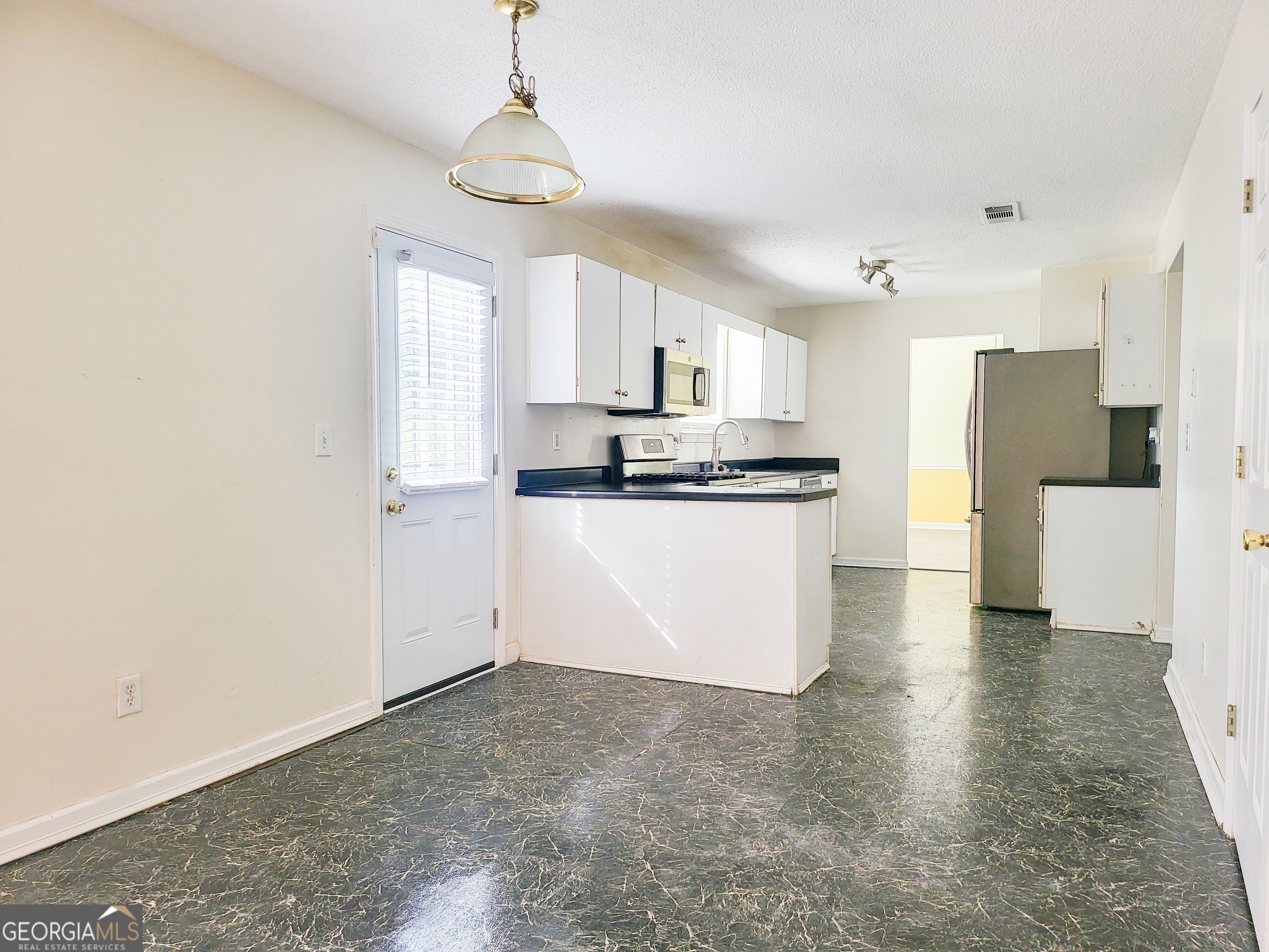6232 Springwater Lane Lithonia, GA 30058 - Photo 7 of 32 a kitchen with stainless steel appliances a refrigerator sink and white cabinets