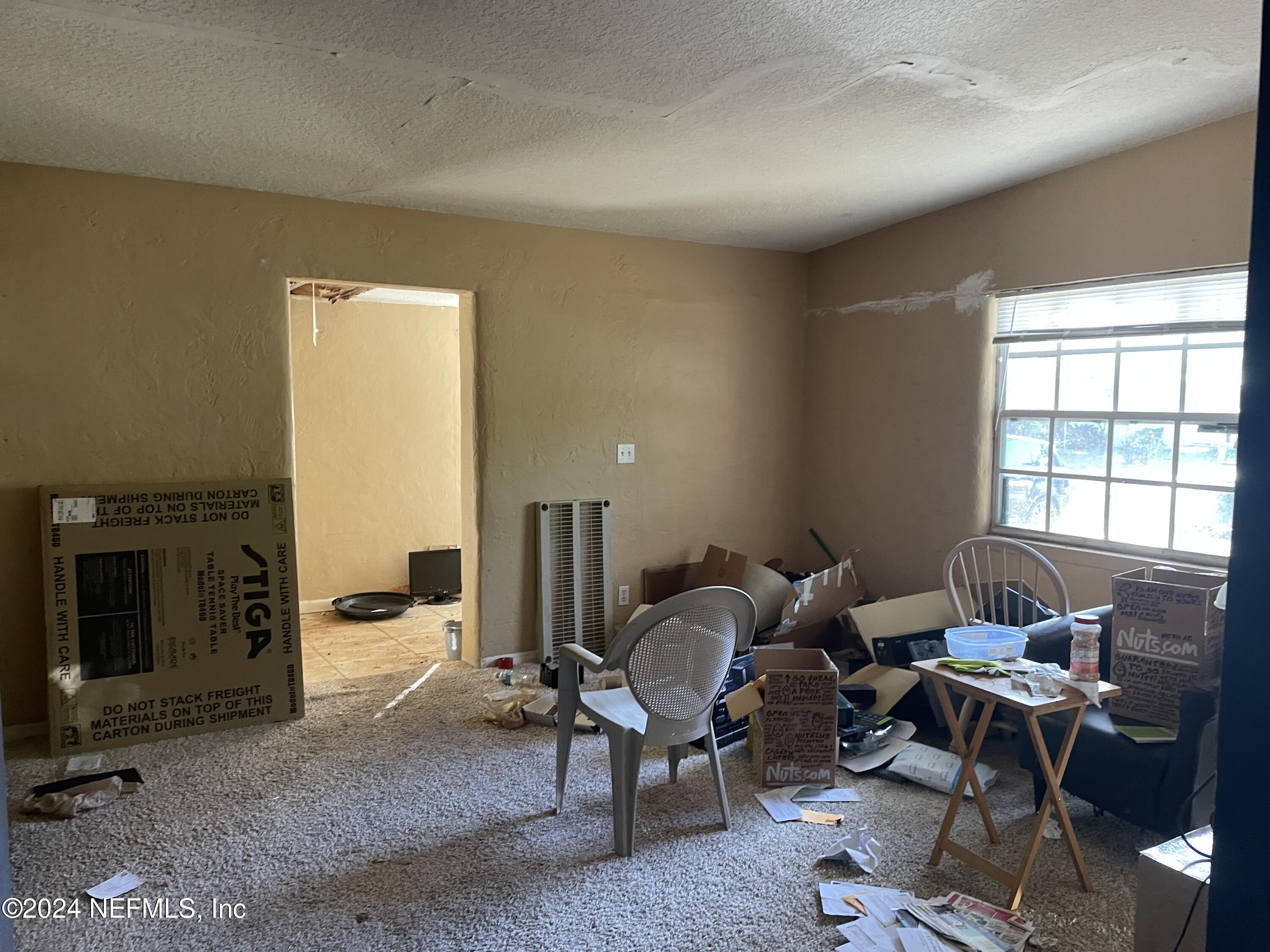 6713 Ector Road Jacksonville, FL 32211 - Photo 11 of 12 a living room with furniture a fireplace and a large window