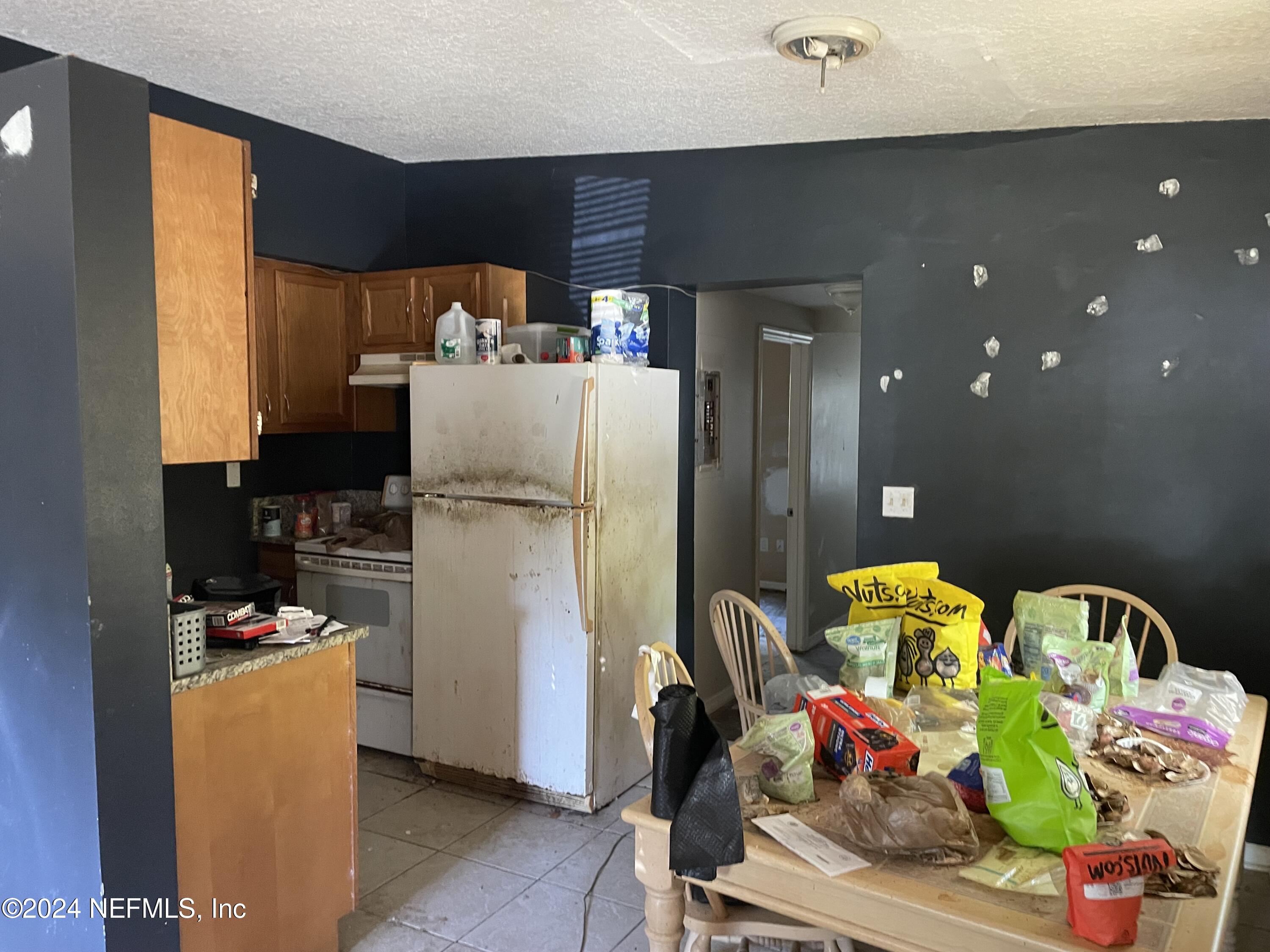6713 Ector Road Jacksonville, FL 32211 - Photo 10 of 12 a kitchen with a refrigerator and a bed