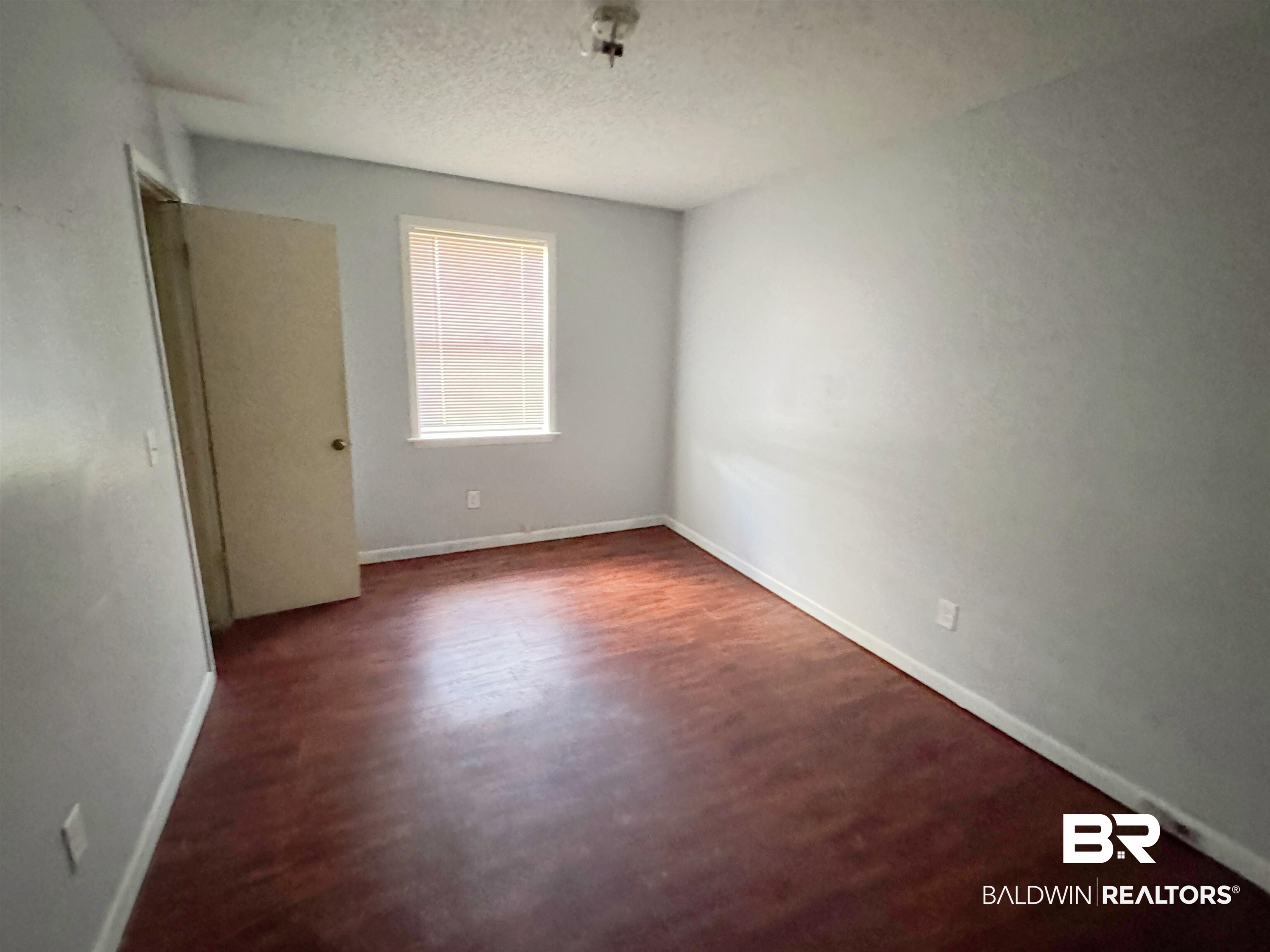 1227 Northgate Drive Atmore, AL 36502 - Photo 7 of 14 Unfurnished room featuring a textured ceiling and dark wood-style floors