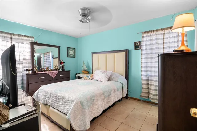 a bedroom with a bed and a flat tv screen on dresser