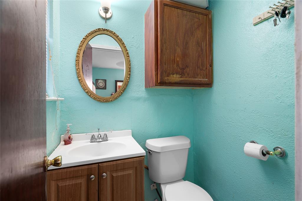 1255 Olden Street Dallas, TX 75211 - Photo 8 of 14 a bathroom with a toilet sink and mirror