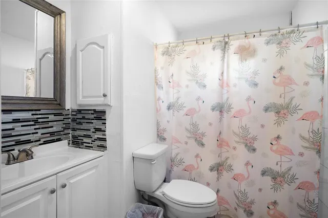 a bathroom with a sink a toilet and shower curtain