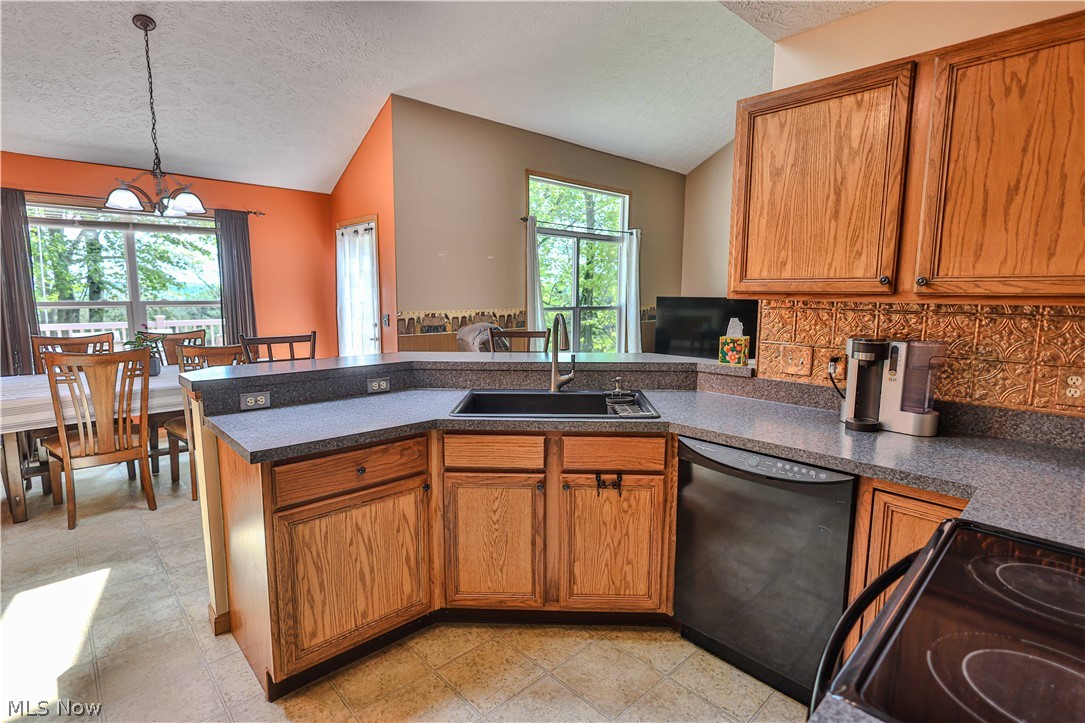 11154 Johnsford Road Southwest Beach City, OH 44608 - Photo 22 of 50 Kitchen featuring wood cabinetry, speckled countertops, black sink, and a copper-toned backsplash