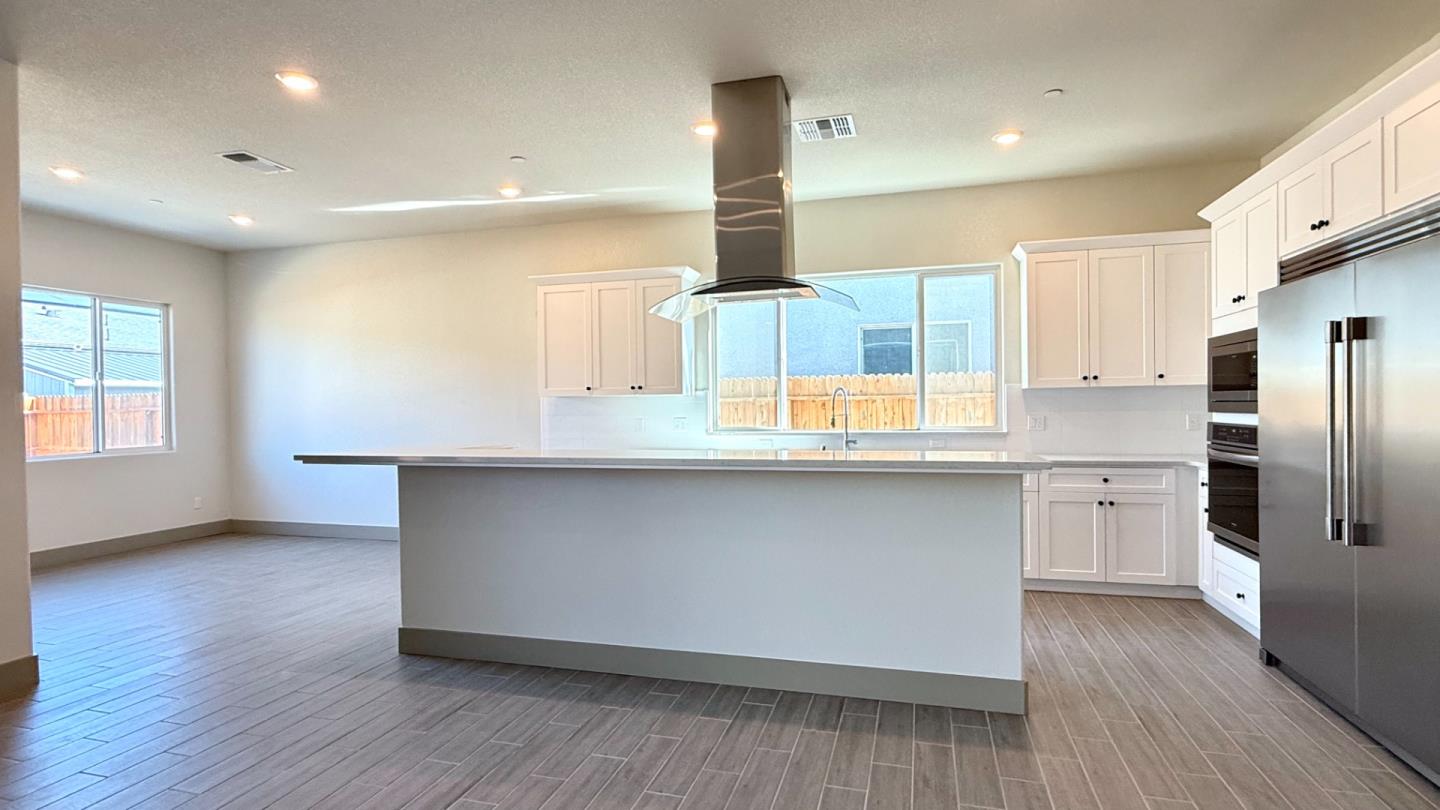 2475 Bastidas Drive Merced, CA 95340 - Photo 19 of 59 a kitchen with stainless steel appliances a refrigerator and wooden floor