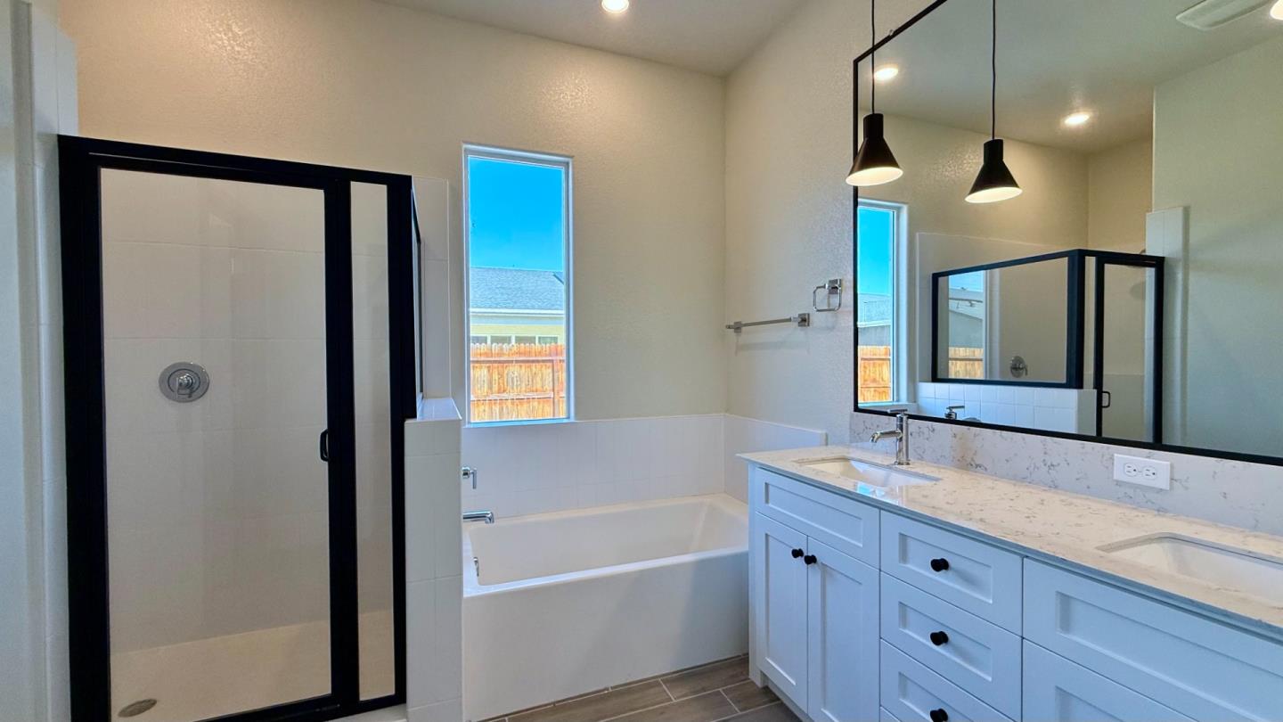 2475 Bastidas Drive Merced, CA 95340 - Photo 30 of 59 a bathroom with a bathtub a sink and a large mirror