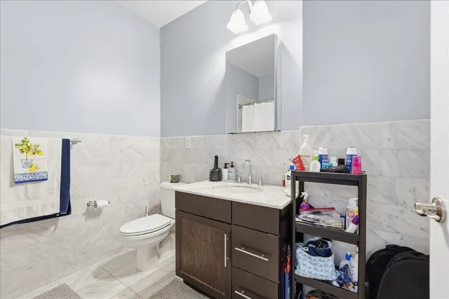 a bathroom with a sink vanity mirror and toilet