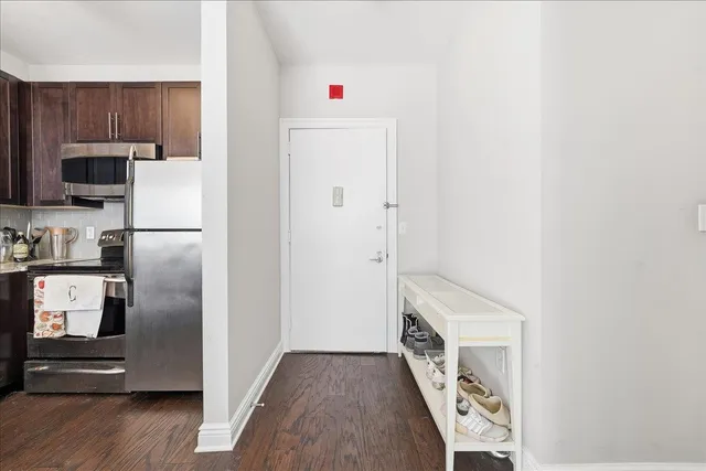 a kitchen with a refrigerator and a stove top oven