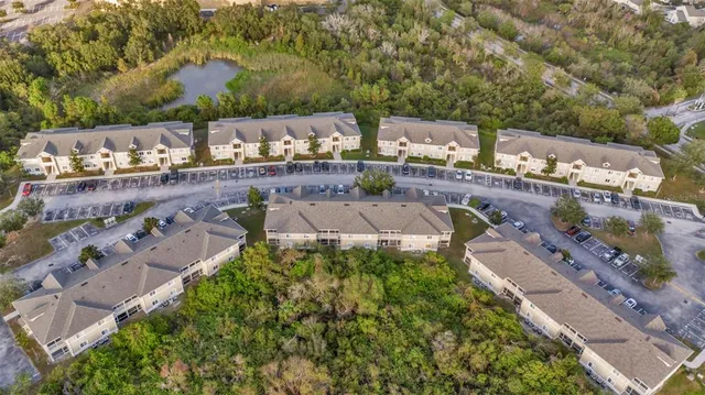 a view of a white house with a big yard and large trees