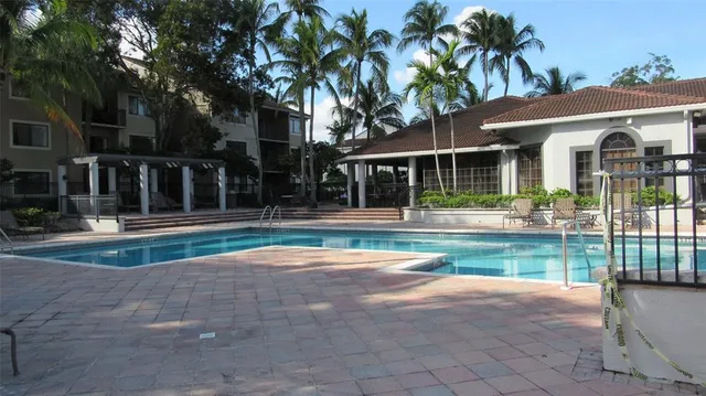 a swimming pool with barbeque oven in front of it