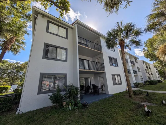 a front view of a house with a garden and trees