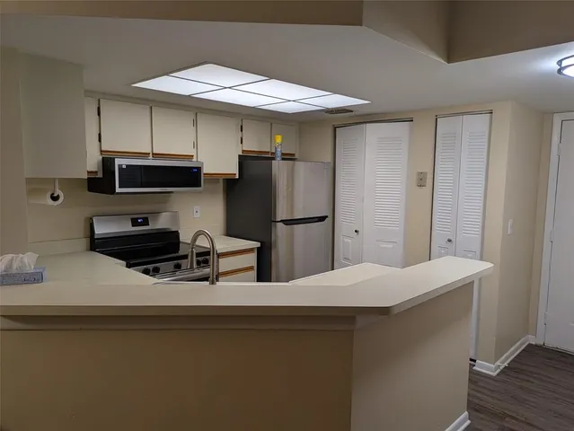 a kitchen with stainless steel appliances a refrigerator a stove a microwave and cabinets